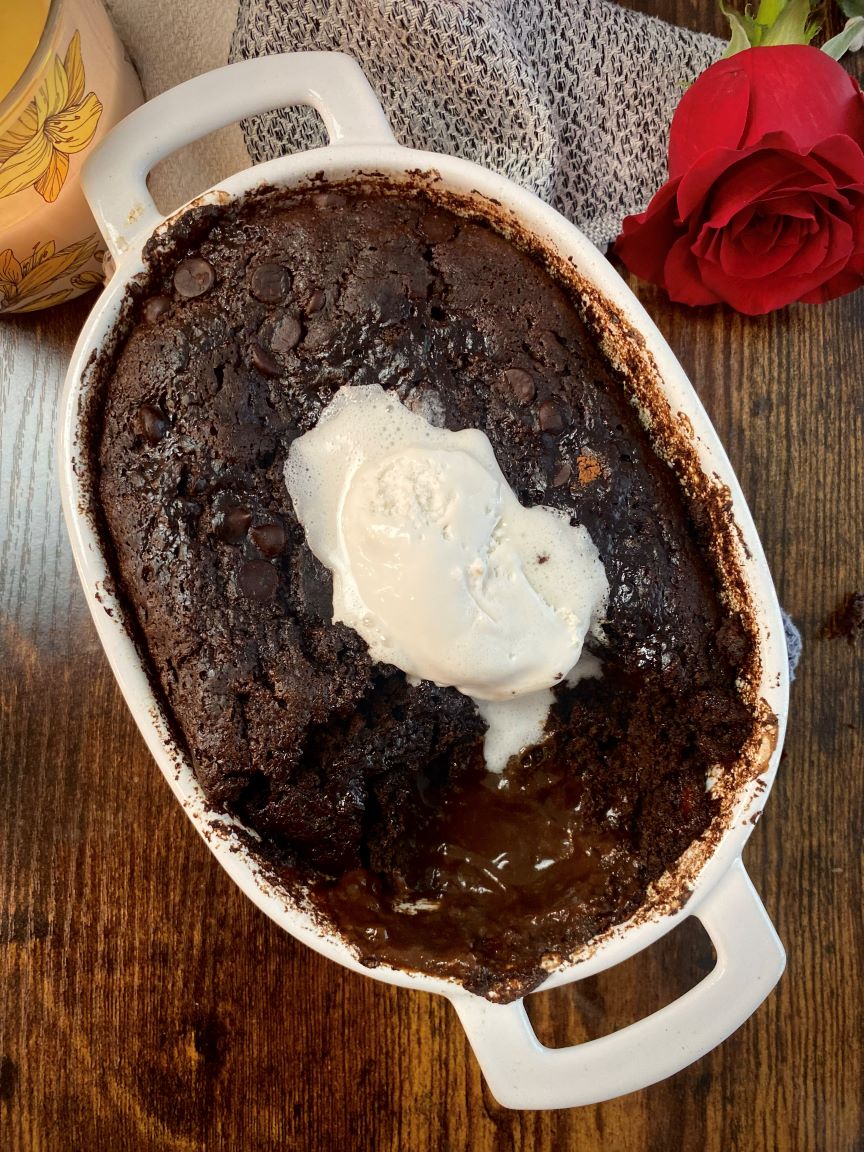 overhead of baked pudding cake with whipped cream